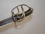 a close up of a sword on a white surface