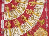 une image représentant une écharpe rouge et blanche ornée de bijoux dorés