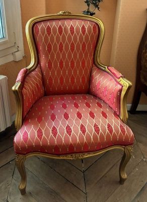 a red and gold chair in the corner of a room