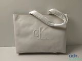 the white bag has a monogram on it and is sitting on a table