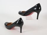 pair of black high heeled shoes on a clear acrylic stand