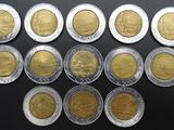 several different coins are arranged in a row on a black surface