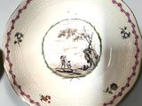 someone is holding a plate with a picture of a man and a dog on it
