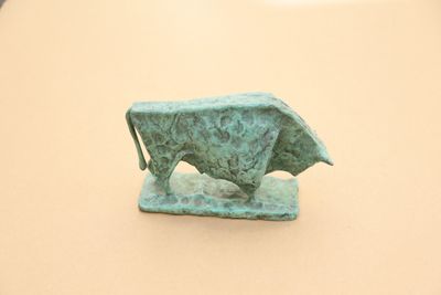 une petite statue de taureau posée sur une table