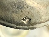 a close up of a metal object with a diamond on it