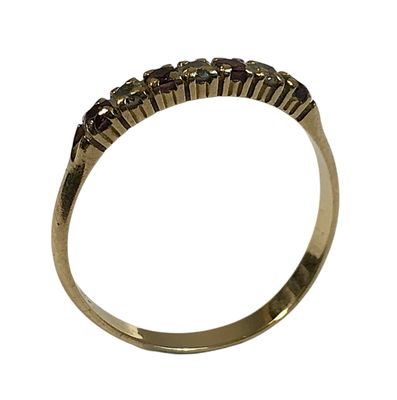 Gros plan sur une bague en or ornée de pierres rouges