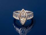 un gros plan d'une bague en diamant posée sur une surface bleue