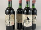 four bottles of wine are lined up on a white surface