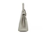 a silver purse with a metal handle on a white background
