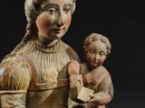 an old wooden statue of a woman holding a child