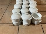 beaucoup de casseroles et poêles blanches posées par terre