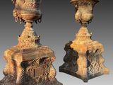 une paire d'urnes anciennes en fonte posées sur des socles, sur fond gris