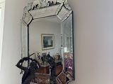 a mirror hanging on the wall above a statue of a man