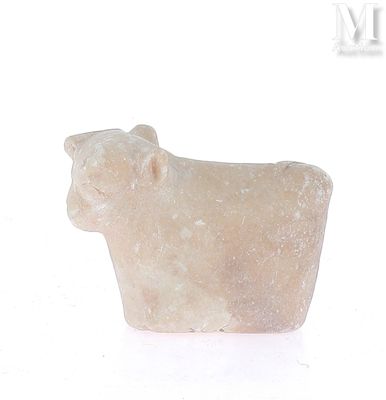 un animal en pierre assis sur une surface blanche