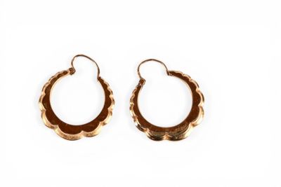 une paire de boucles d'oreilles en or sur fond blanc