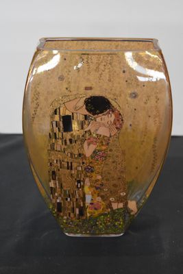 a glass vase with a painting on it on a table