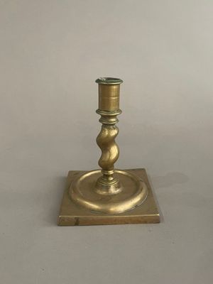 paire de bougeoirs anciens en laiton reposant sur un socle carré