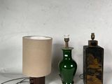 trois vases verts et une lampe posés sur une surface blanche