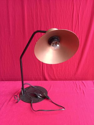a lamp that is sitting on a table with a pink background
