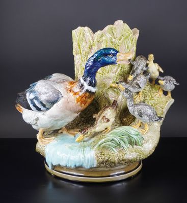 une figurine représentant un canard et un caneton posés sur une feuille