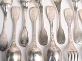 a lot of silver spoons and forks on the table