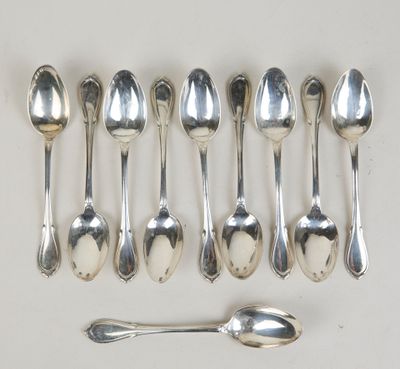 six cuillères et un repose-cuillère sur une surface blanche