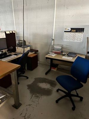 un bureau avec un ordinateur et une chaise dans une pièce
