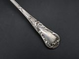 a silver spoon with a handle on a black surface