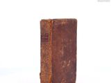 an old book that is sitting on a white surface