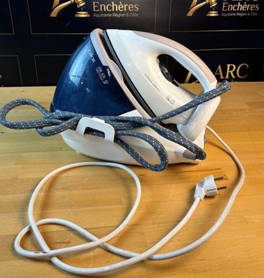 un fer à repasser à vapeur bleu et blanc posé sur une table en bois