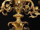 an antique bronze candelier with chers and chers on a black background