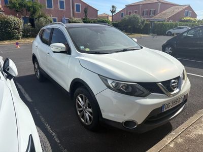 La Nissan QX blanche est garée sur le bord de la route.