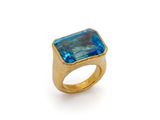 Gros plan sur une bague en or ornée d'une topaze bleue
