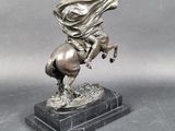 statue of a man riding a horse on a marble base