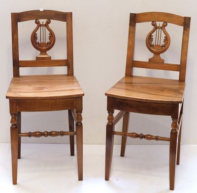 pair of wooden chairs with a harp on the back of them