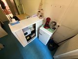 a small refrigerator in the corner of a small room