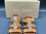 a photo of a pair of sandals with a box in the background
