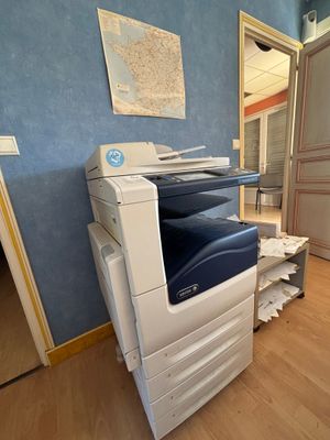 une photo d'une imprimante dans une pièce où une carte est accrochée au mur