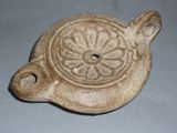 a small pottery object with a flower design on it