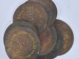 several old metal discs with chinese writing on them on a white surface