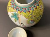 a small vase with a small bowl on the table