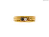 un gros plan d'une bague en or sertie de deux saphirs