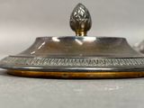 a silver and gold plate with a flower on it