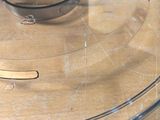a glass lid on a plastic container on a wooden table