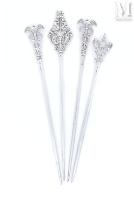 trois cuillères en argent ornées de motifs élaborés sur fond blanc