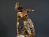 a statue of a woman with a clock on a table