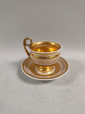 gold cup and saucer on a white background