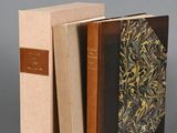 two books sitting on top of each other on a gray surface