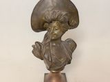 statue en bronze représentant une femme coiffée d'un chapeau