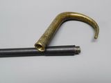 a small metal object with a long handle on a white surface
